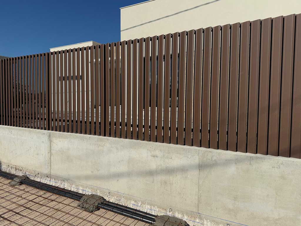 Vallado perimetral de aluminio color madera. Cerramiento elegante y duradero para vivienda unifamiliar.